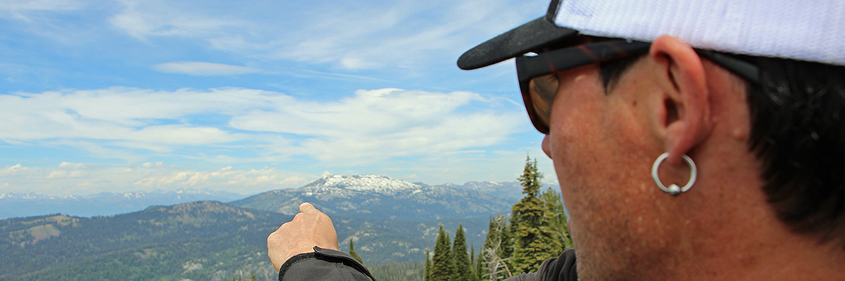 Scenic lift rider points toward granite mountain