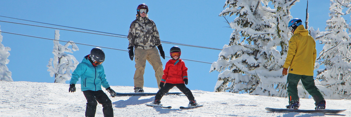 Family of four skis on bear chair lift