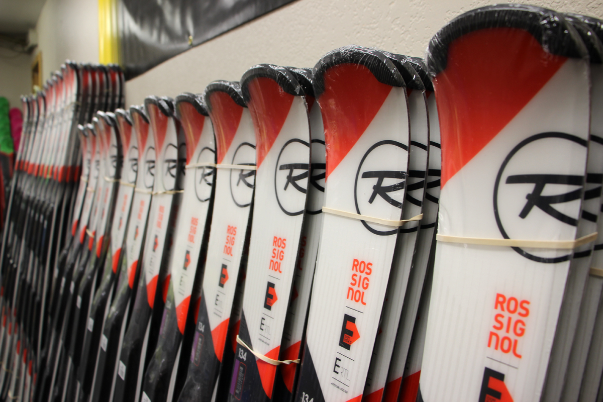 new skis lined up against a wall
