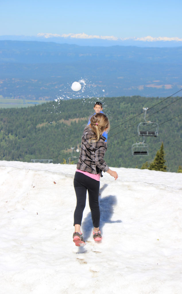 girl tosses a snowball on the summit