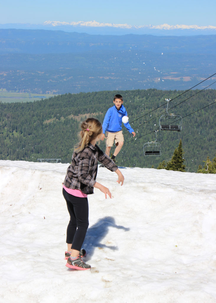kids throw snowballs on summit
