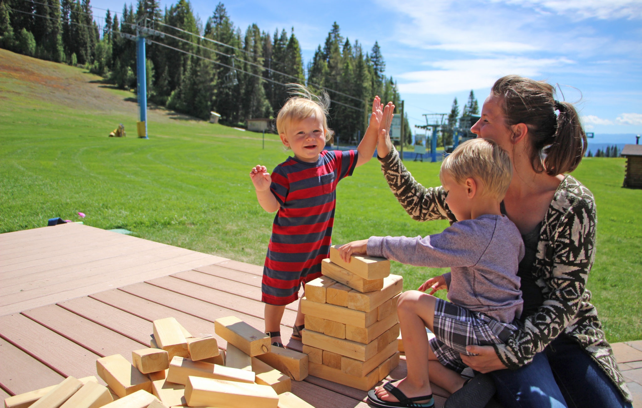 young kids play jenga in plaza high five
