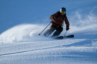 Brundage Mountain resort showing snow-covered slopes with powder terrain, scenic mountains backdrop, and trails winding through alpine winter landscape