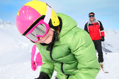 Snowboarders and skiers riding downhill runs with chairlift and lift access to alpine terrain during peak season