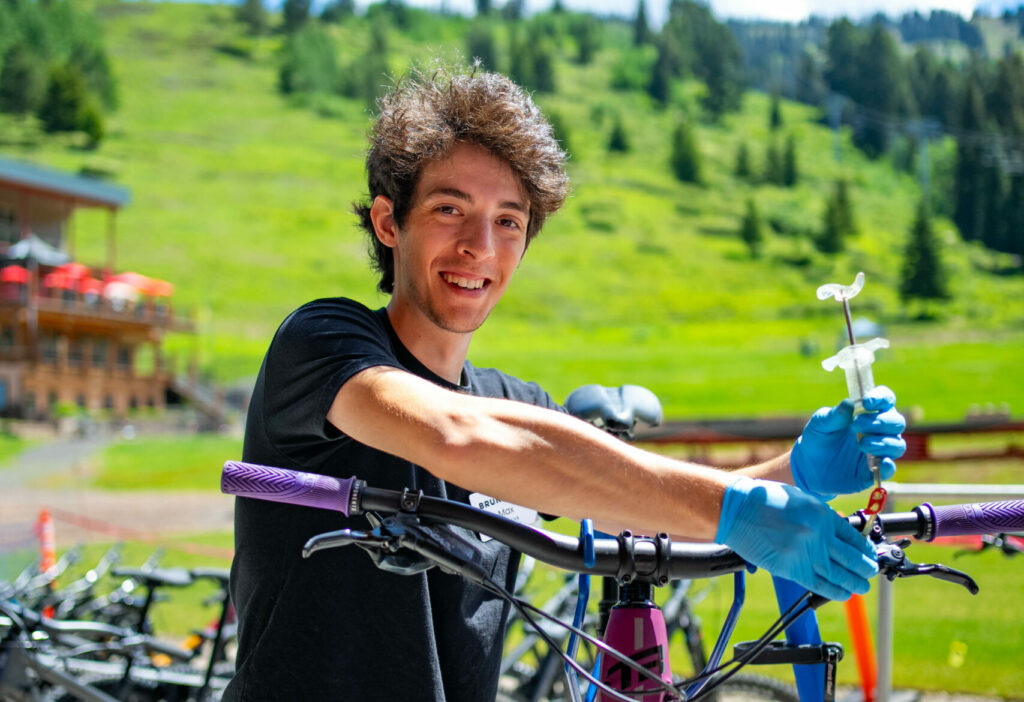 Bike mechanic working on breaks outside of the Mountain Adventure Center. 